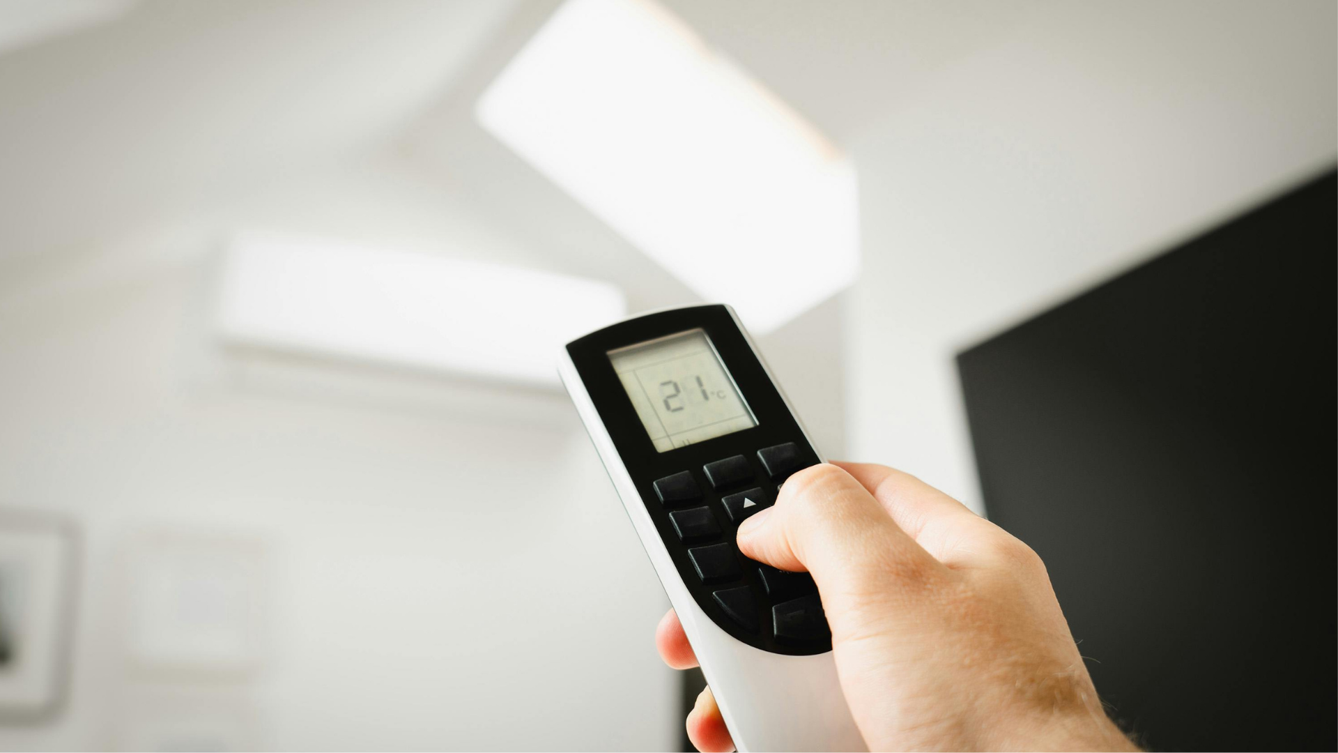 Hand using AC remote to troubleshoot cooling issue in San Diego home
